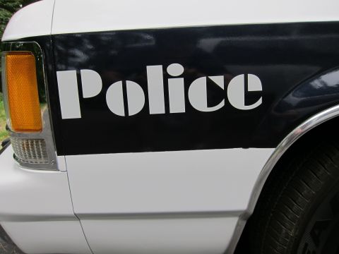 1991 Ford LTD Crown Victoria - The word 'Police' is stenciled in white on a black stripe along the side of a white vehicle.