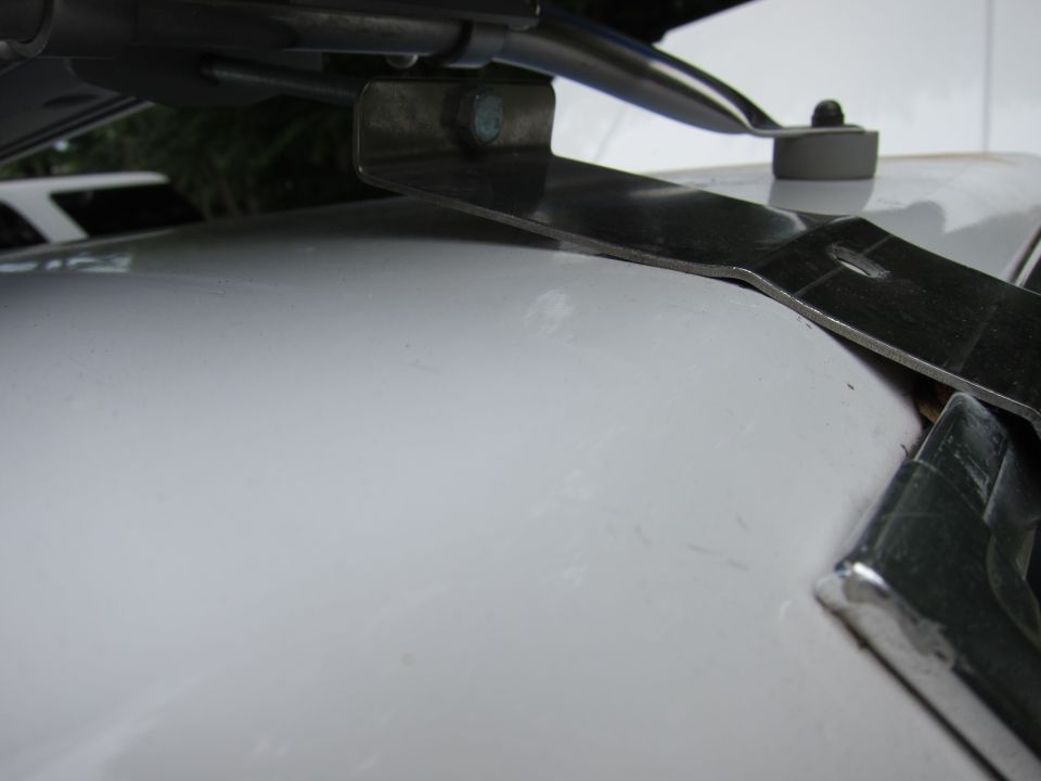 Close-up of a metal bracket attached to a white surface, with chrome trim visible