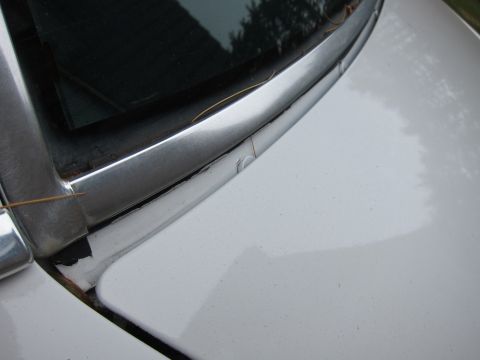 1991 Ford LTD Crown Victoria - Detail shot of the chrome trim around the windshield on a white vehicle.