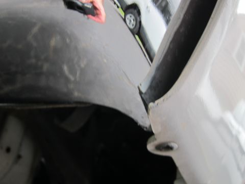 1991 Ford LTD Crown Victoria - A partial view of a vehicle's fender and wheel well, with another car in the background.
