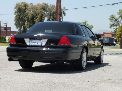 2003 Ford Crown Victoria - Tail-end view of black sedan, Ford oval, SVT emblem and dual exhaust tips