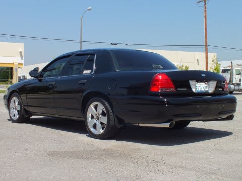 2003 Ford Crown Victoria - Black Crown Victoria from behind-left, trunk badge visible, truck parked behind