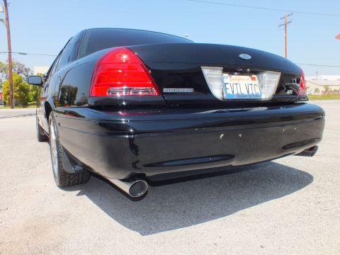 2003 Ford Crown Victoria - Close rear view of a black Crown Victoria with Ford badge, California plate and single chrome exhaust tip