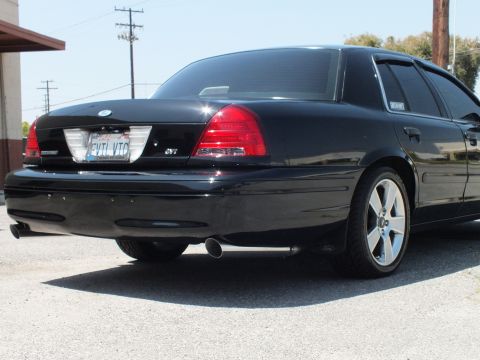 2003 Ford Crown Victoria - Black Crown Victoria rear quarter showing SVT badge, dark taillights and chrome exhaust tip