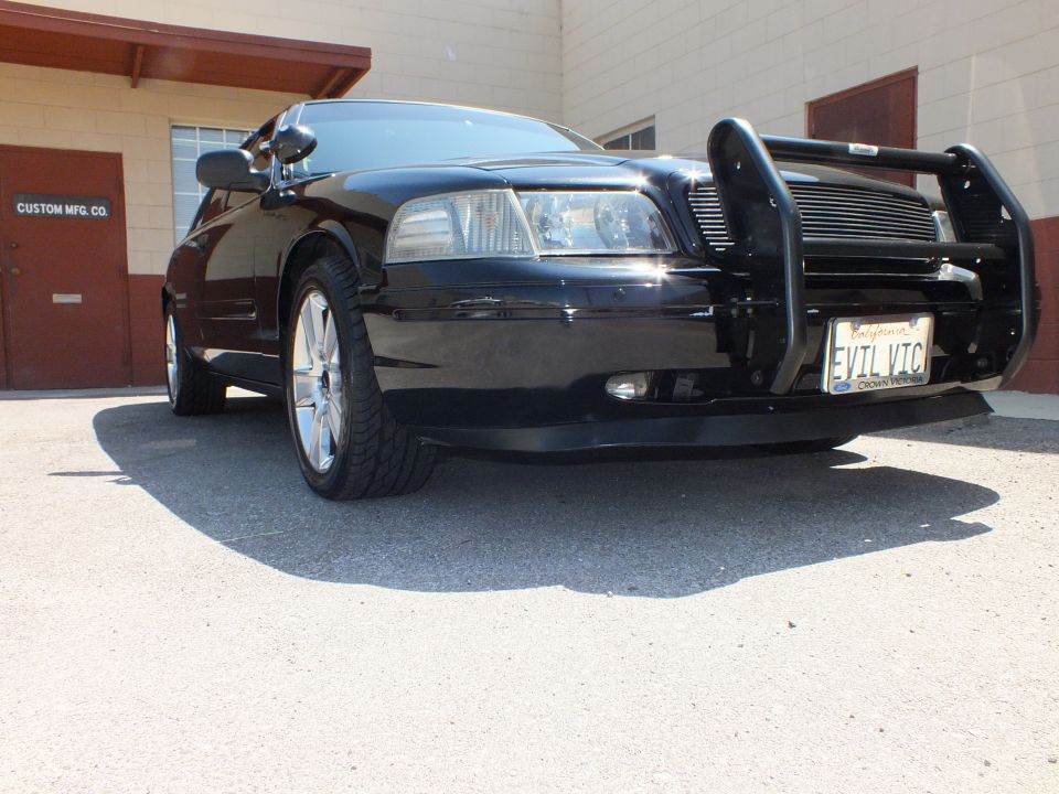 Low front quarter of black Ford Crown Victoria with push bar grille guard and EVIL VTC plate