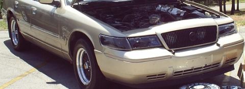 2000 Mercury Grand Marquis - Front view of a 2000 Mercury Grand Marquis, hood up, parked outdoors.