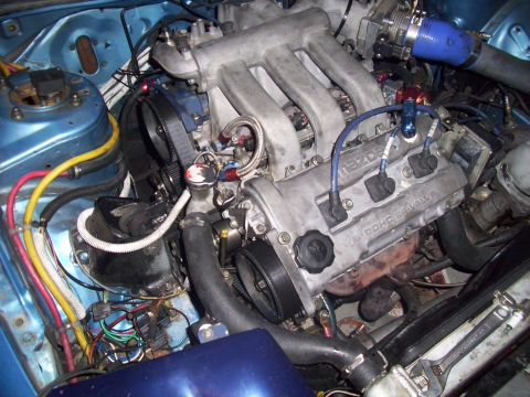 1995 Ford Probe - Close-up view of a modified Mazda V6 engine, highlighting the intake manifold and timing belt assembly.