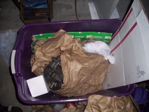 1995 Ford Probe - A car part is stored in a purple bin with other items, including boxes and plastic bags.