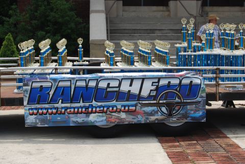 1975 Ford Ranchero - A trailer displays numerous trophies and a banner with the word "RANCHERO" and a website address for-sale website.