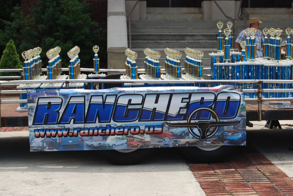 Trailer with blue and gold trophies and a banner reading "RANCHERO" with a bull logo and "www.ranchero.us"