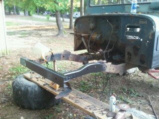 1978 Ford Bronco - This vehicle's frame is elevated on wooden blocks and a large tire, with the SuperMotors logo prominently displayed.