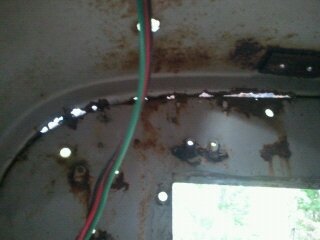 1978 Ford Bronco - Close-up of rusted interior metal panel with wiring and holes. SUPERMOTORS.NET logo is present.