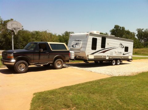 1994 Ford Bronco - A Ford Bronco tows a travel trailer on a sunny day.