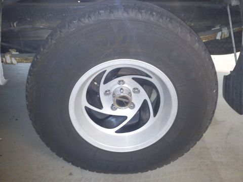 1997 Chevrolet Silverado 1500 - A close-up shot focuses on the wheel and tire assembly of a truck, showing the tread pattern and rim design.