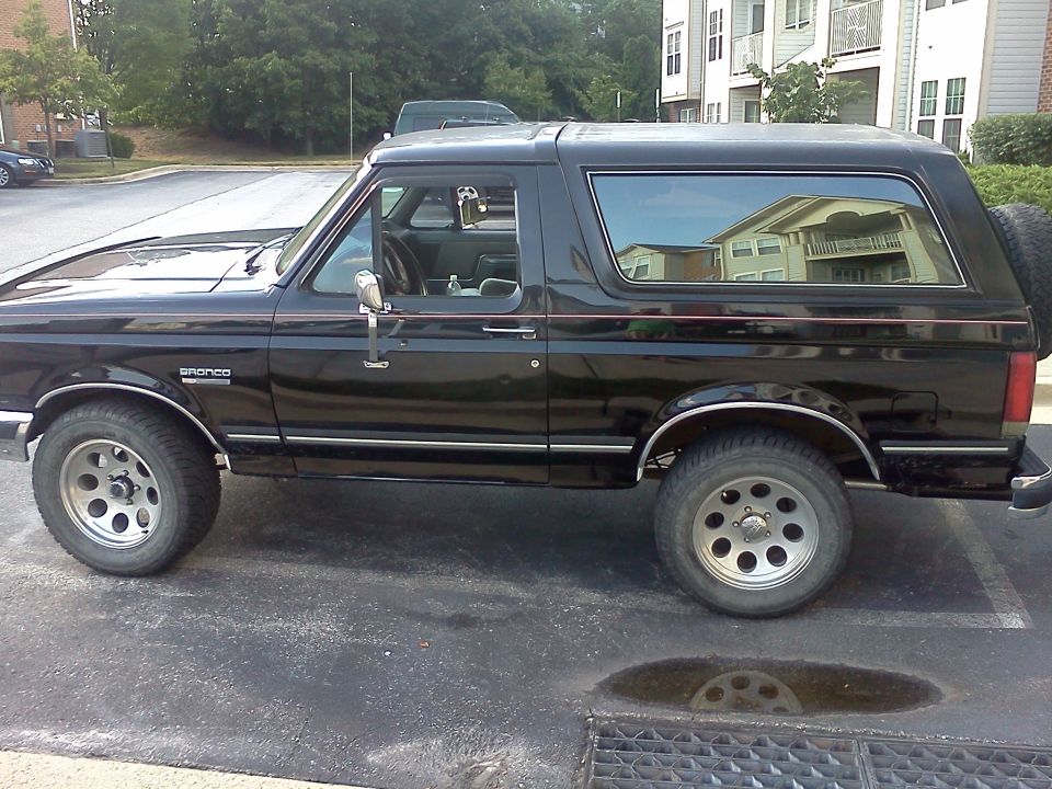 Side view of a black 1990 Ford Bronco parked in a lot