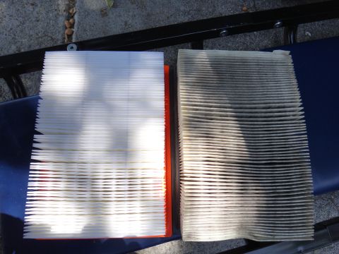 2003 Ford Taurus - Comparison of a new air filter and a used, dirty air filter, indicating the need for replacement.