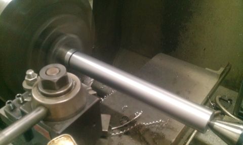 1987 Ford Bronco - A metal rod is being machined on a lathe, with metal shavings scattered around the workpiece.