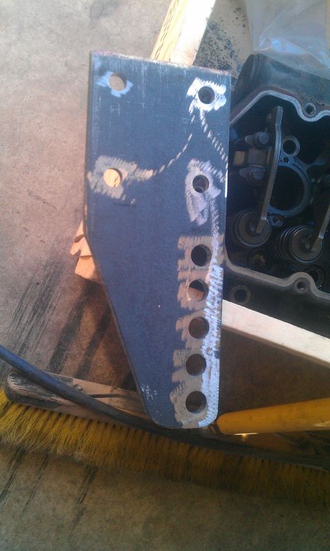 1987 Ford Bronco - A custom metal bracket with multiple holes sits beside an open engine valve cover.