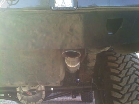 1996 Ford Bronco - Undercarriage view of a modified truck, showing the rear axle, exhaust, and large off-road tires.