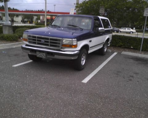 1996 Ford Bronco - This two-tone 1996 Ford Bronco is parked in a lot, showing its front three-quarter view.