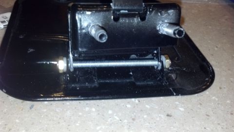 1995 Ford Bronco - Close-up view of a black automotive part, showing mechanical fasteners and mounting points.