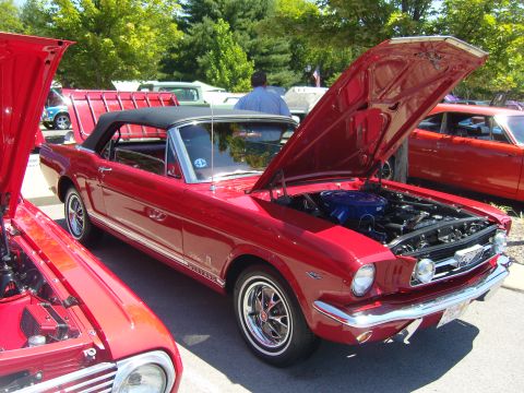 2007 Ford Mustang - A classic red 1965 Ford Mustang convertible is displayed with its hood open, revealing the engine bay.