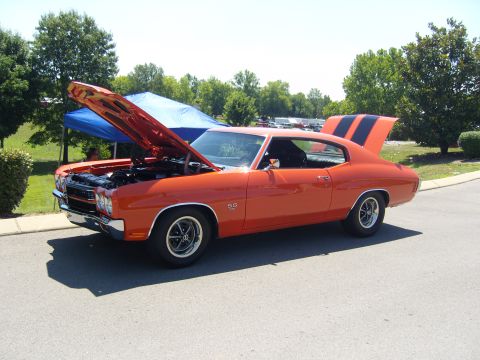 2007 Ford Mustang - A classic orange muscle car with its hood and trunk open, displaying racing stripes on the trunk lid.