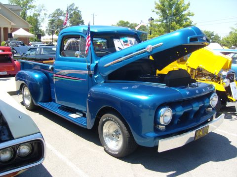 2007 Ford Mustang - This custom blue 1951 Ford F-series pickup truck is displayed with its hood open at a car show.