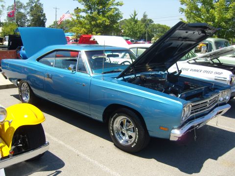 2007 Ford Mustang - A blue classic car is displayed with its hood open at an outdoor event, alongside other vehicles.