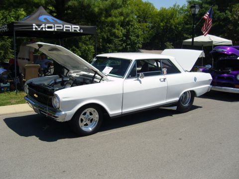2007 Ford Mustang - A white classic coupe is displayed with its hood open at an outdoor event, with another vehicle visible to the right.