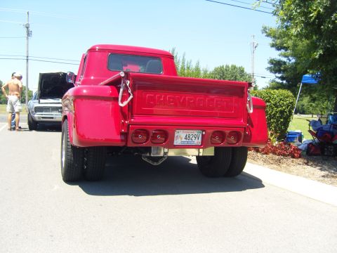 2007 Ford Mustang - A bright red Chevrolet pickup truck is shown from the rear, dual rear wheels and a custom bumper with integrated taillights.