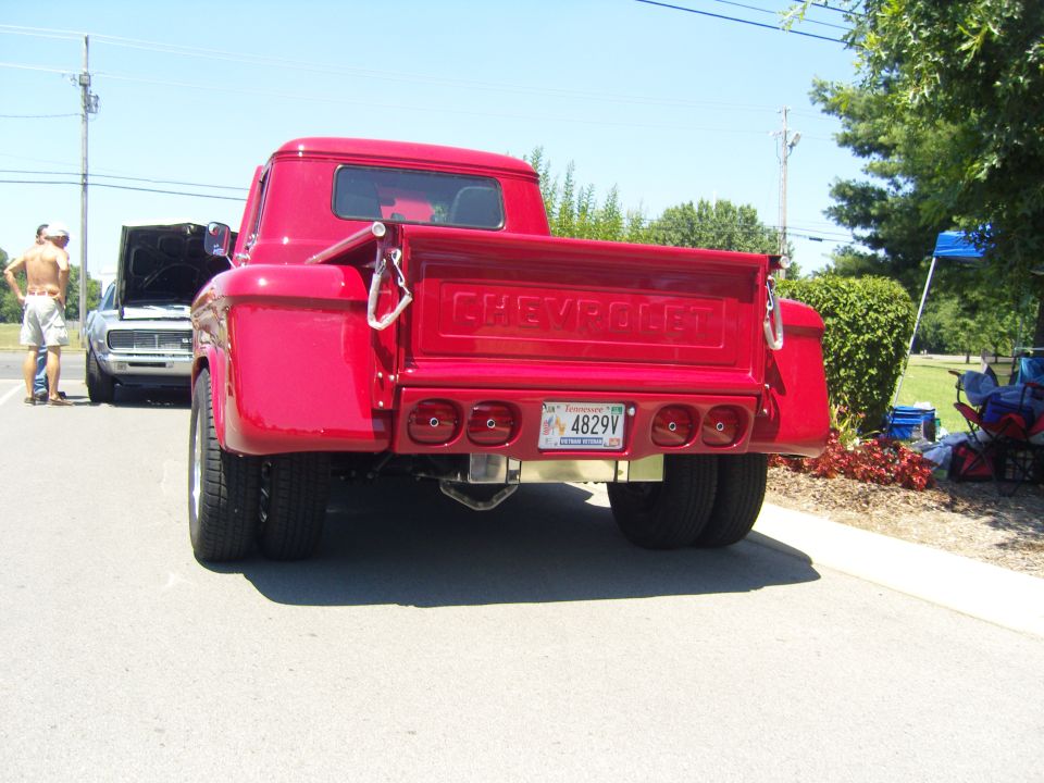 Red Chevrolet pickup truck rear view with dual rear wheels and custom taillights