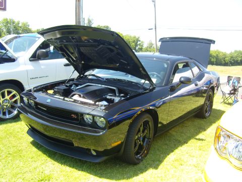 2007 Ford Mustang - A black Dodge Challenger is displayed with its hood open at an outdoor car show.