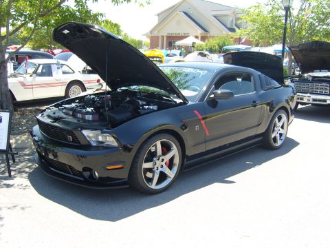 2007 Ford Mustang - A black Ford Mustang is displayed with its hood open at an outdoor car show.