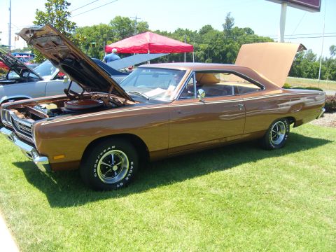 2007 Ford Mustang - A brown 1969 Plymouth Road Runner is displayed with its hood and trunk open at a car show.