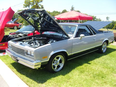2007 Ford Mustang - Two cars with hoods open at an outdoor car show, one is a silver El Camino.