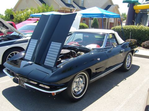 2007 Ford Mustang - A black convertible with its hood open, revealing the engine, parked outdoors.