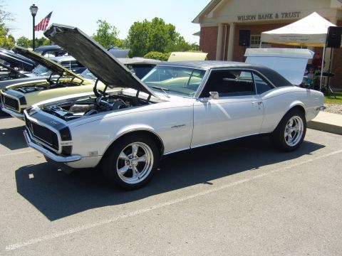 2007 Ford Mustang - A silver 1967 Chevrolet Camaro is displayed with its hood open at an outdoor car show.