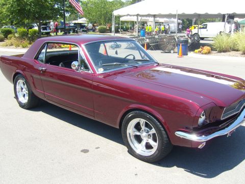 2007 Ford Mustang - A classic maroon coupe with white racing stripes is parked outdoors under a sunny sky.
