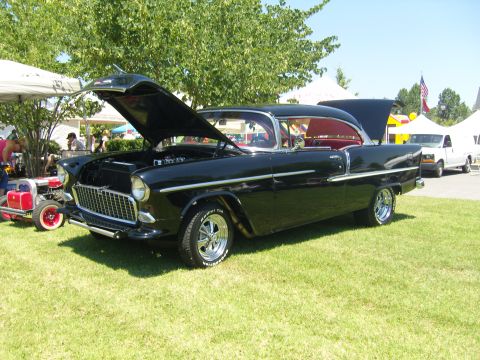 2007 Ford Mustang - A black 1955 Chevrolet Bel Air is displayed with its hood open at an outdoor event.