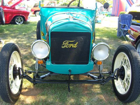 2007 Ford Mustang - A teal Ford hot rod is parked on grass with other vehicles in the background.