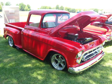 2007 Ford Mustang - A classic red pickup truck is displayed with its hood open, revealing the engine bay.