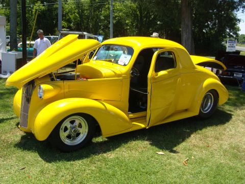 2007 Ford Mustang - A bright yellow custom coupe sits on display with its hood and driver's door open.