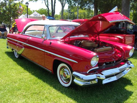 2007 Ford Mustang - A red and white 1955 Mercury Monterey two-door hardtop is displayed with its hood open at an outdoor car show.