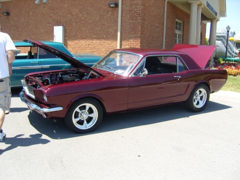 2007 Ford Mustang - A maroon classic coupe is displayed with its hood and trunk open, parked next to a teal classic car.