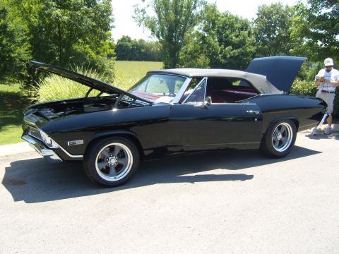 2007 Ford Mustang - A classic black convertible with its hood and trunk open sits on a paved surface outdoors.
