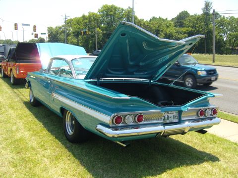 2007 Ford Mustang - Rear view of a teal 1959 Chevrolet Impala at a car show, with other vehicles nearby.