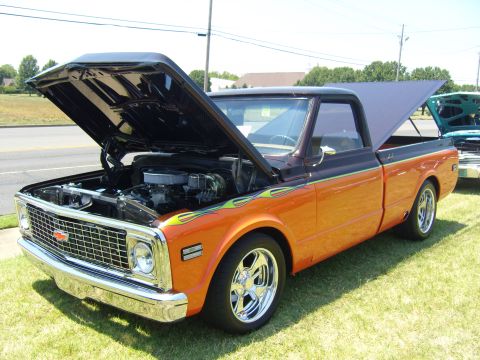 2007 Ford Mustang - A customized pickup truck with its hood and bed open sits on display on a grassy area.