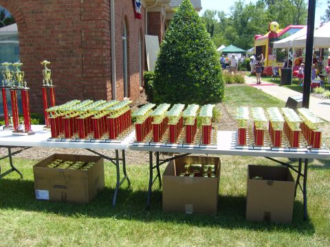 2007 Ford Mustang - Numerous trophies are displayed on tables outdoors, suggesting an awards ceremony or competition event.