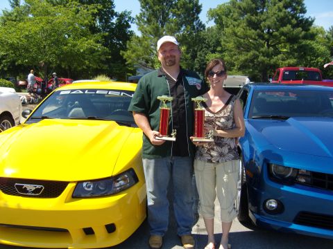 2007 Ford Mustang - A man and woman hold trophies in front of a yellow Saleen Mustang and a blue Chevrolet Camaro.